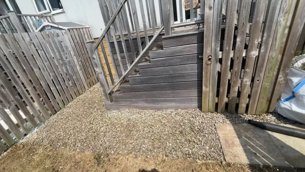 The same steps and decking clear, with new gravel laid across the ground beside them