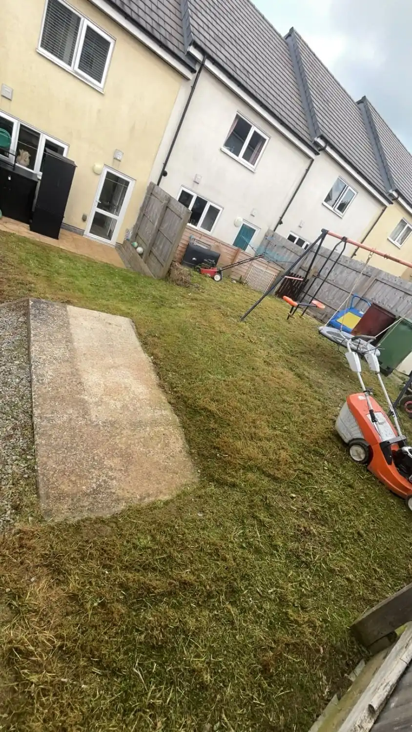 The same lawn cut short and even, with the patio and the swing set clear again