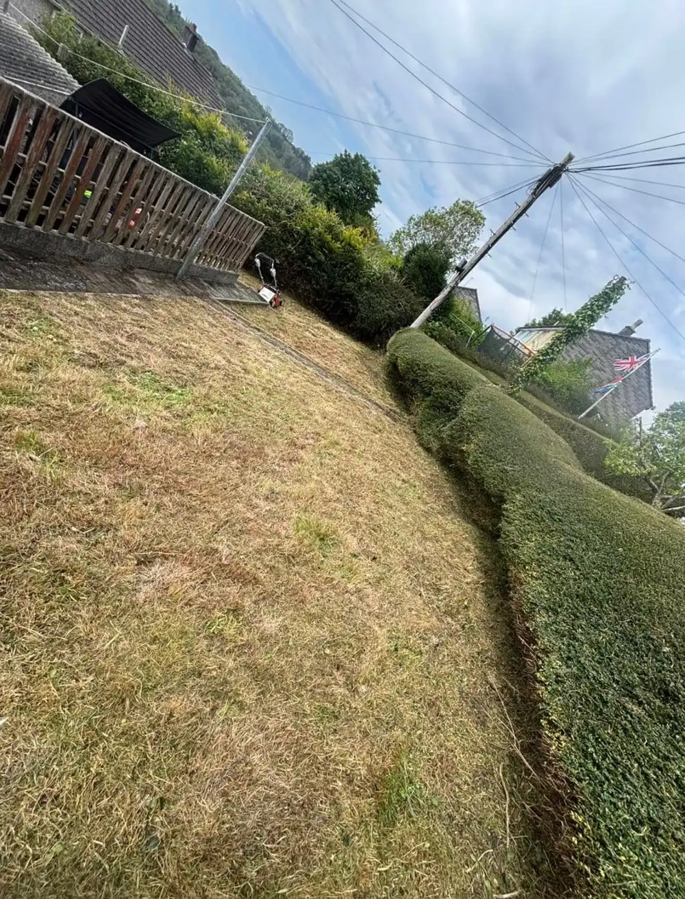 The same bank cut down to a short, even finish with the houses behind now visible