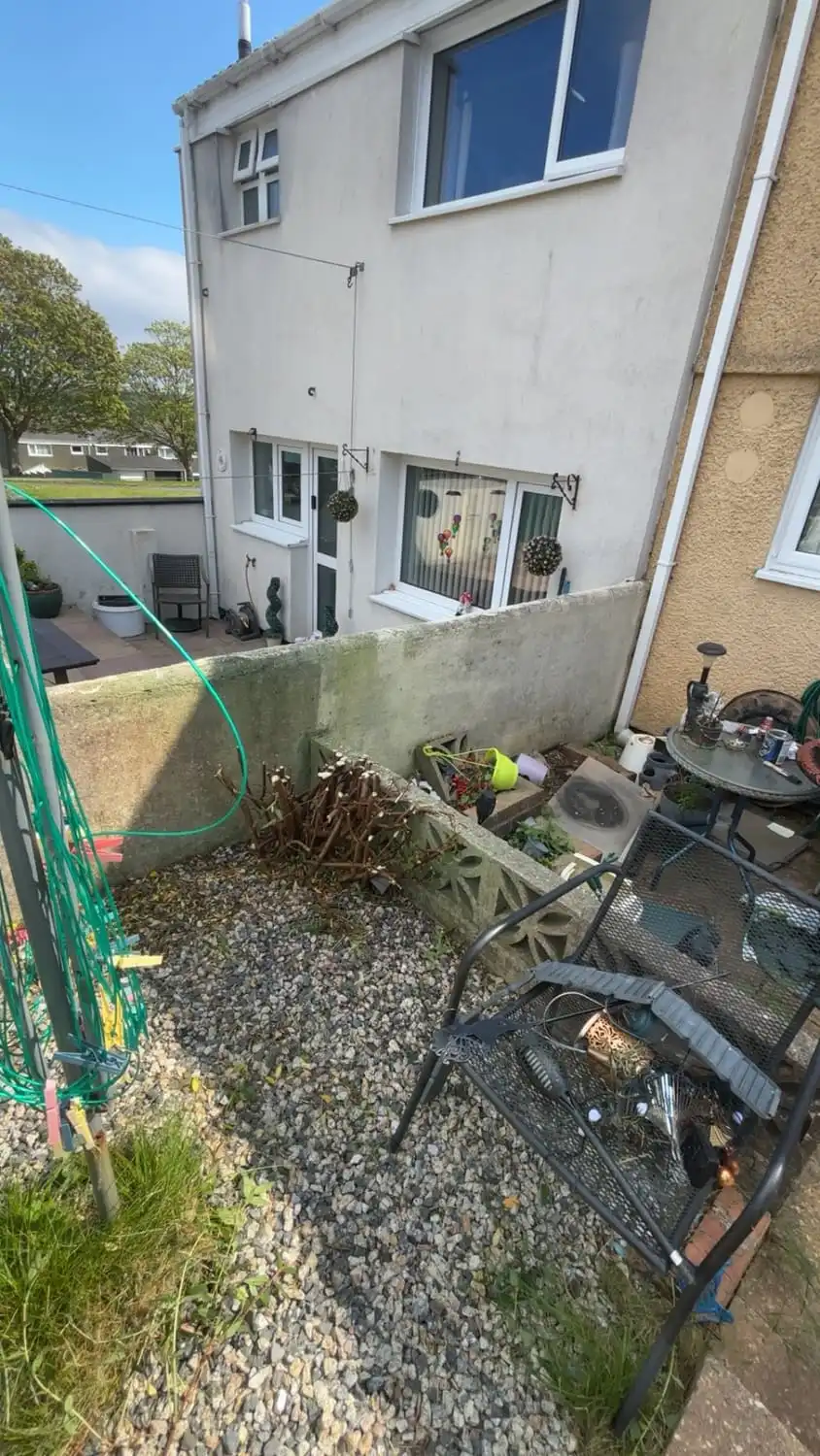 The same garden with the shrub removed and the gravel raked clear across the space